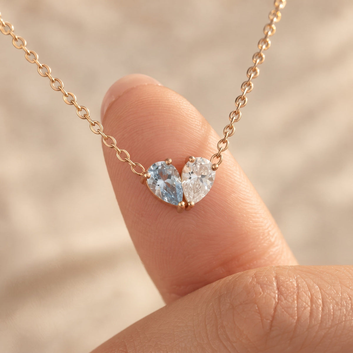 Close-up of the Elora Necklace pendant against a fingertip