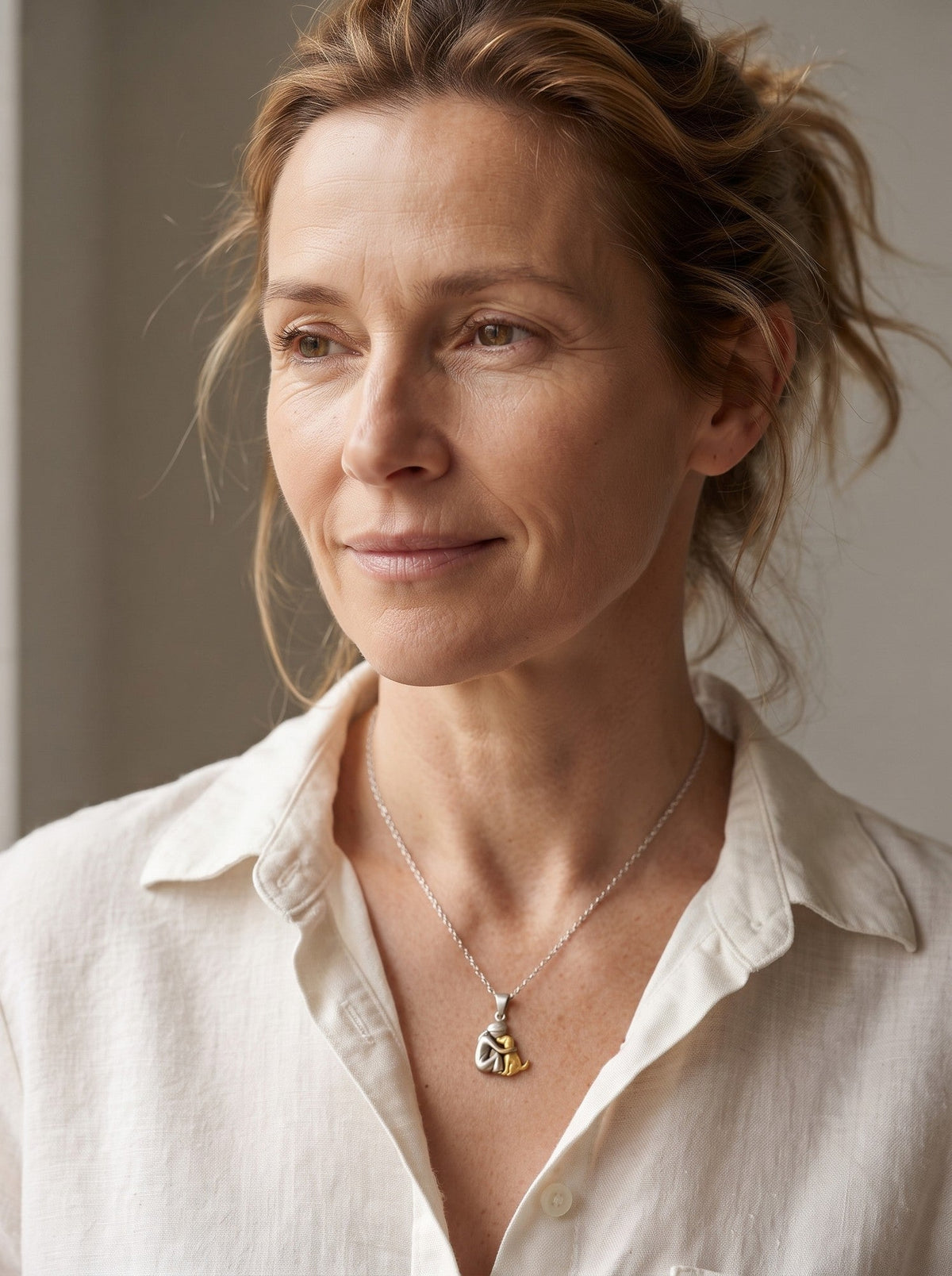Woman wearing the Eternal Hug Necklace over a linen shirt