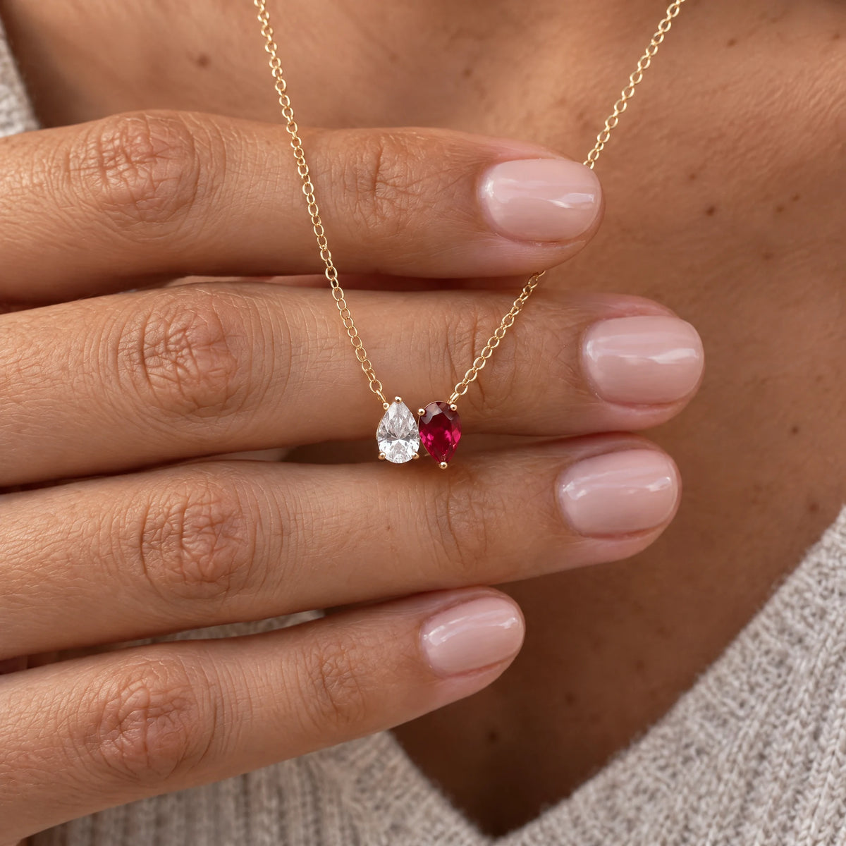 Kindred Necklace with two birthstones resting on a hand