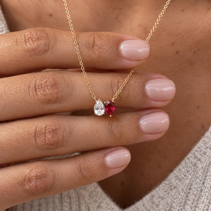 Kindred Necklace with two birthstones resting on a hand