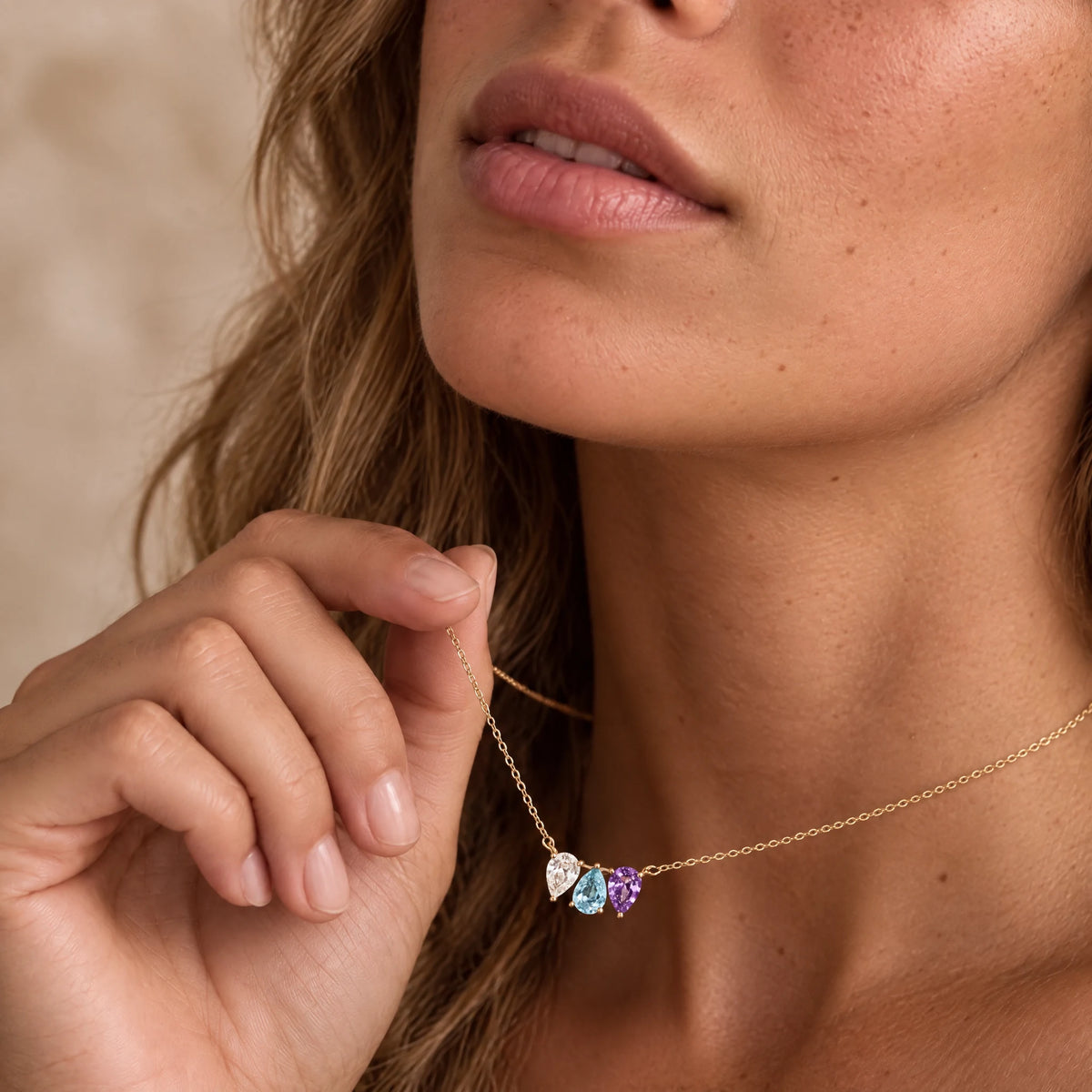 Woman wearing the Kindred Necklace with three birthstones